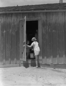 Child of Texas sharecropper carrying water, 1937. Creator: Dorothea Lange