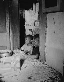 Living Conditions Gallery: Three children waiting in the kitchen while their mother prepares the... Washington, D.C, 1942