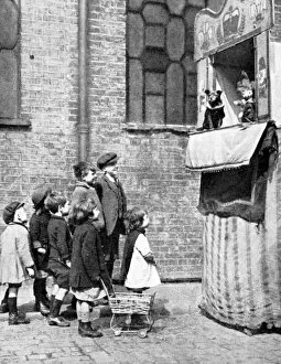 Mr Punch Gallery: Children watching a Punch and Judy show in a London street, 1936. Artist: Donald McLeish
