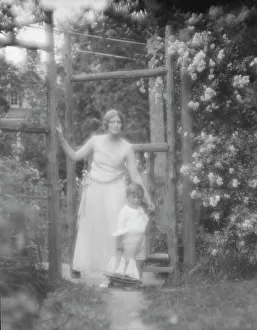 Group Portraits Prints: Conroy, Frank, Mrs. and child, standing by a garden gate, 1923 Creator: Arnold Genthe