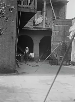 Cleaning Prints: Courtyard with cistern and woman cleaning