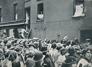 Plundering Gallery: Crowd watching the looting of a German house in Poplar, c1914