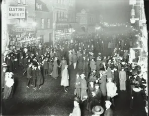 Deptford Gallery: Crowds in Deptford High Street shopping after dark, London, 1913