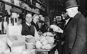 Shopkeeper Gallery: A customer inspects a haggis, London, 1926-1927