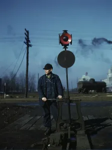 Daniel Senise throwing a switch while at work in an Indiana Harbor Belt Line railroad yard, 1943. Creator: Jack Delano