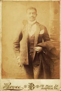 Dapper man, coat draped over his arm, and cane in hand, c1880-c1889. Creator: Unknown