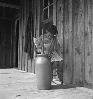Porch Gallery: Daughter of Negro tenant churning butter. Randolph County, North Carolina, 1939