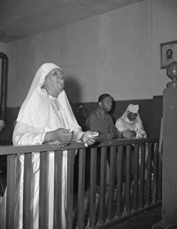 Parks Gordon Alexander Buchanan Collection: A disciple of the St. Martins Spiritual Church praying before the altar... Washington, D.C. 1942