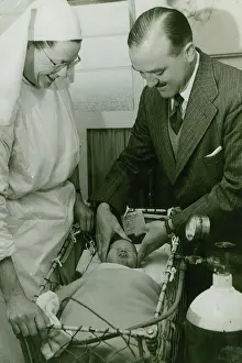 Employee Prints: Dr Geoffrey Mutton and Matron Joan Gardner attend to a baby at St Monan's Hospital