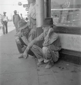 Americans Prints: Drought farmers line the shady side of the main street of the town