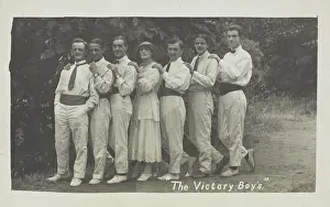 Cross Dressing Prints: Entertainers, one in drag, pose in a line in front of foliage