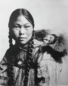 Inuit Prints: Eskimo mother with child on back, c1906. Creator: Lomen Brothers