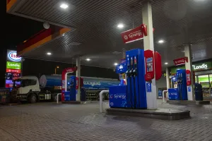 Esso petrol station forecourt with tanker delivering fuel, 2020. Creator: Tim Woodcock