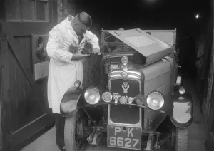Motor Maintenance Gallery: FA Thatcher working on his 1929 Triumph Super Seven. Artist: Bill Brunell