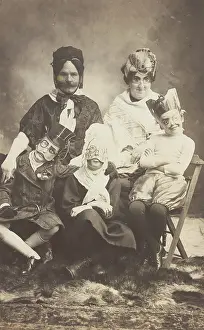 Cross Dressing Prints: A family, all members wearing grotesque masks, the father in drag, c1910. Creator: Unknown