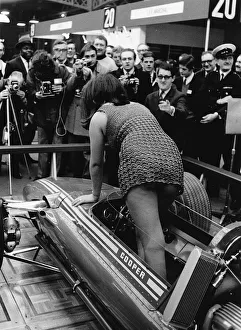 Racing Car Prints: Female model climing in to Cooper F5000 at 1969 Racing Car show. Creator: Unknown