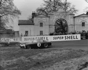 Ferrari 250 SWB spins as Jaguar E type passes. Creator: Unknown
