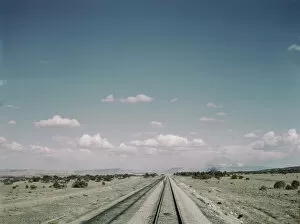 Flagman standing behind his train to flag oncoming trains at a small siding... New Mexico, 1943. Creator: Jack Delano