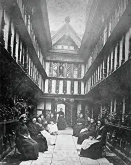 Ford's Hospital, Coventry: residents seated in the courtyard looking toward the street, c1880s