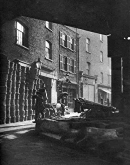 Fruit baskets piled against houses at Borough Market, London, 1926-1927. Artist: Whiffin