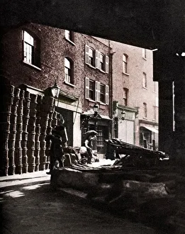 Fruit Basket Prints: Fruit baskets piled against houses at Borough Market, London, 1926-1927. Artist: Whiffin