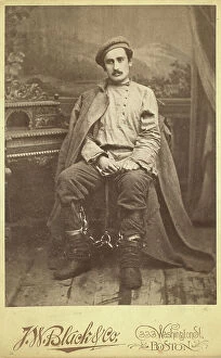 Chain Collection: Full-length portrait of a man in convict clothing and leg irons, seated..., between 1880 and 1886