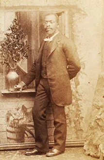 Full-length portrait of man, with studio props, c1880-c1889. Creator: Richmond Photograph Co