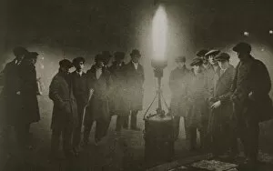 Gathering around an acetylene flare at a traffic control point in the fog, early 20th century