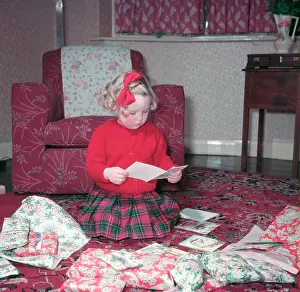 Gift Prints: Girl opening her Christmas cards and presents, c1955. Creator: Arthur Charles Kirby Ware