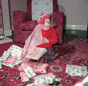 Gift Prints: Girl opening her Christmas presents, c1955. Creator: Arthur Charles Kirby Ware