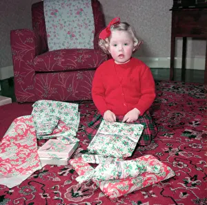 Gift Prints: Girl opening her Christmas presents, c1955. Creator: Arthur Charles Kirby Ware