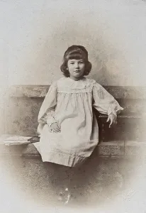 Contented Prints: A girl, sitting on a stone bench with a fan folded at her side