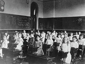 Obedience Prints: Girls and boys seated at desks in classroom