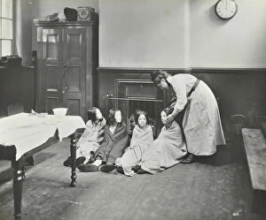 Guildhall Library Art Gallery: Girls drying their hair by the fire after a bath, Chaucer Cleansing Station, London, 1911