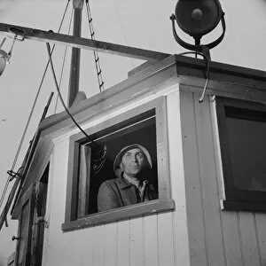 Gloucester, Massachusetts. Lorenzo Scola maneuvers ship during mackerel chase, 1943. Creator: Gordon Parks
