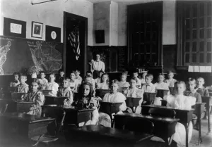 Grade school children posed in classroom, with teacher standing in back... Washington DC, (1899?). Creator: Frances Benjamin Johnston