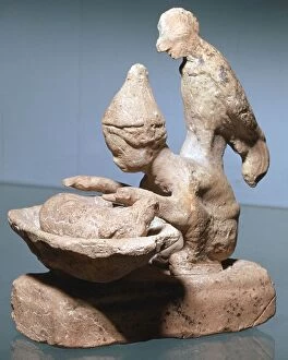 Greek terracotta of a haruspex inspecting pigs entrails