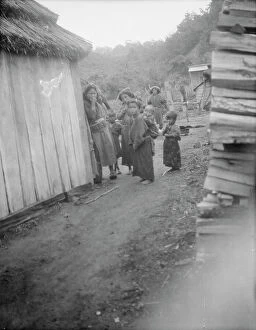 Thatch Collection: Group of Ainu children standing in a passageway between huts, 1908. Creator: Arnold Genthe