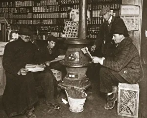 Warmth Prints: A group of men around a stove in a shop, USA, c1910