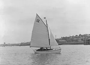 Dinghy Collection: A Hamble River Class dinghy (No 12) sailing close-hauled, 1921. Creator: Kirk & Sons of Cowes