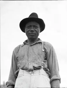 Sharecropper Prints: At Hill House, Mississippi - He wears the union button, 1936. Creator: Dorothea Lange