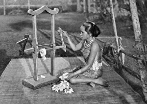 Sea Dayaks Gallery: Iban woman making thread with a mangle, Borneo, 1922. Artist: Dr Charles Hose