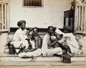 Crouching Prints: Two Indian barbers wearing turbans shaving the heads of two Indian men