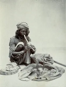 Crouching Prints: An Indian snake charmer squatting down playing his pipe