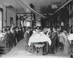 Interior view of dining hall, decorated for the holidays, with students... Tuskegee Institute, c1902 Creator: Frances Benjamin Johnston