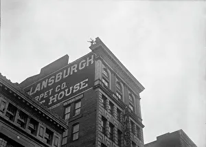 Publicity Stunt Prints: J. Reynolds, Performing Acrobatic And Balancing Acts On High Cornice Above 9th Street