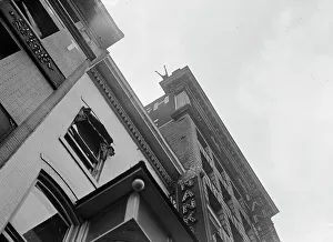 J. Reynolds, Performing Acrobatic And Balancing Acts On High Cornice Above 9th Street, N.W. 1917. Creator: Harris & Ewing. J. Reynolds, Performing Acrobatic And Balancing Acts On High Cornice Above 9th Street, N.W. 1917