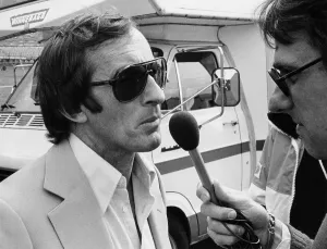 Dark Glasses Prints: Jackie Stewart being interviewed, 1980