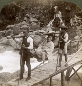 Images Dated 17th July 2008: Japanese woman in a yamakago (mountain chair) crossing the torrential Daiya river near Nikko, Japan