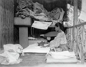 Javanese(?) woman sitting in room working with textiles at exhibit featuring foreign... 1892. Creator: Frances Benjamin Johnston